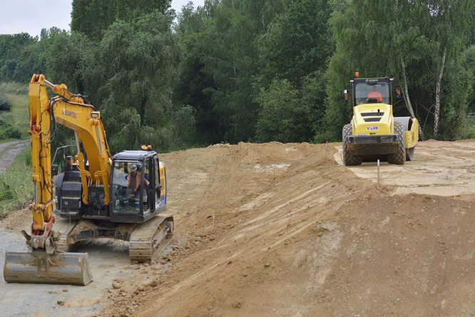 Sur un chantier, une pelle et un rouleau compresseur