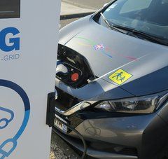 Bornes de charge électrique V2G et voiture en arrière-plan